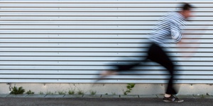 Eine Person rennt vor einer Wand entlang.