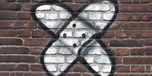 Grafitti eines Pflasters, das auf eine Backsteinwand gesprüht ist.